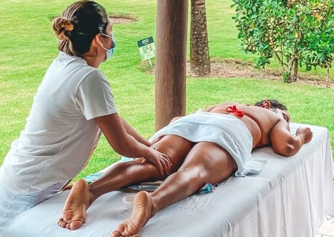 Mulher recebendo massagem em um hotel de experiências